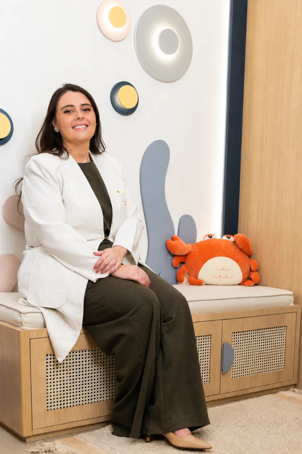 Dra. Gabriela Ramos sentada na sala de espera infantil do seu consultório de neuropediatria no Rio de Janeiro.